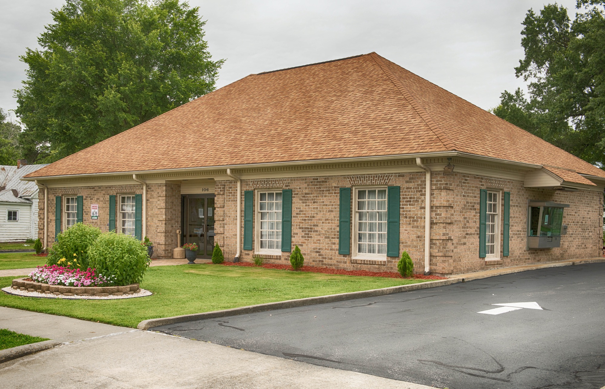 Side view of the brick main office and parking lot